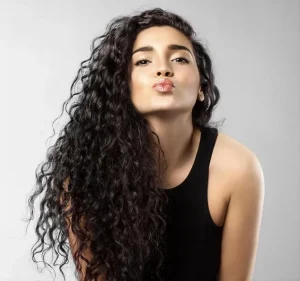 High quality natural looking human hair extensions on a woman, showcasing beautiful, voluminous curly real hair.