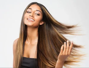 High quality natural looking human hair extensions on a smiling woman, showcasing beautiful, flowing real hair.
